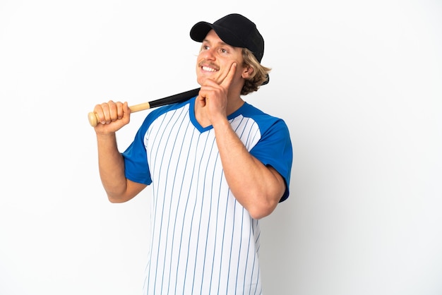 Young blonde man playing baseball isolated on white background thinking an idea while looking up