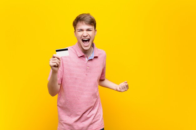 Young blonde man with a credit card