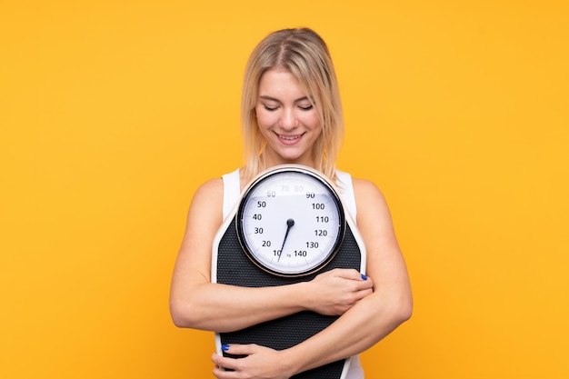 Young blonde Russian woman with weighing machine