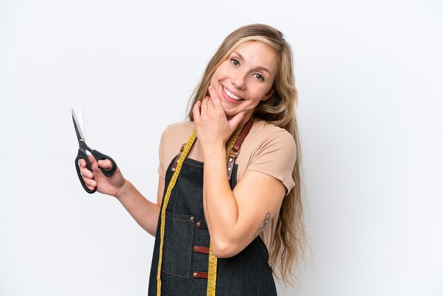 Foto giovane sarta bionda donna isolata su sfondo bianco felice e sorridente