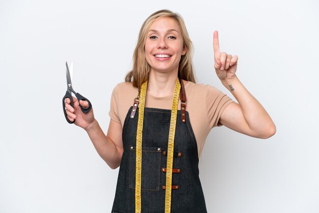 Young blonde seamstress woman isolated on white background pointing up a great idea