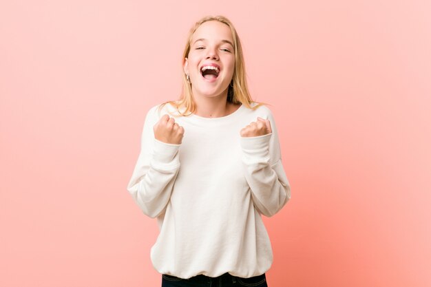 Young blonde teenager woman cheering carefree and excited.