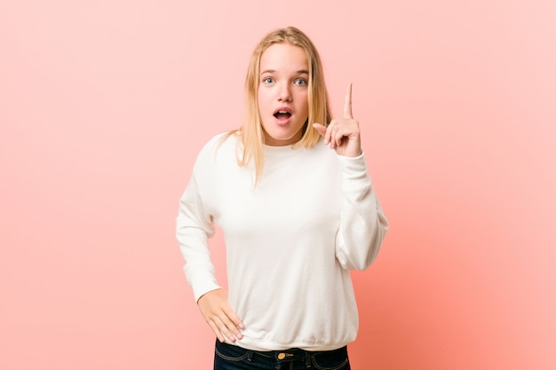 Giovane donna bionda dell'adolescente che ha un'idea, concetto di ispirazione.