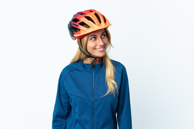 Young blonde Uruguayan cyclist woman thinking an idea while looking up