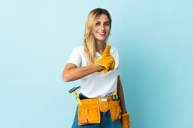 Young blonde Uruguayan electrician woman blue giving a thumbs up gesture