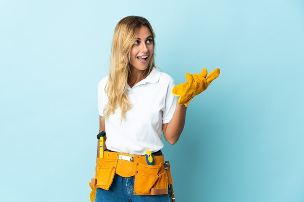 Young blonde Uruguayan electrician woman blue intending to realizes the solution while lifting a finger up