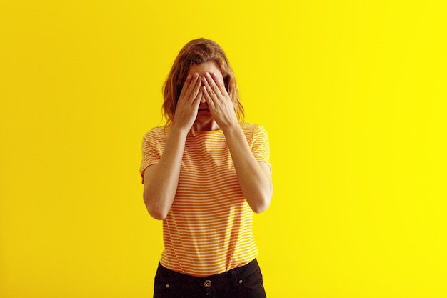 Young blonde woman  against flat color wall