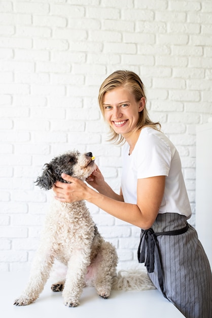 犬の歯を磨く若いブロンドの女性