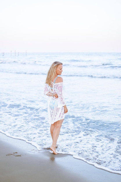 Photo a young blonde woman by the beach