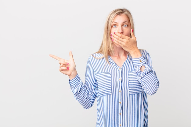 Young blonde woman covering mouth with hands with a shocked