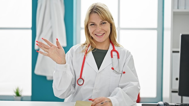 Young blonde woman doctor smiling confident speaking at clinic