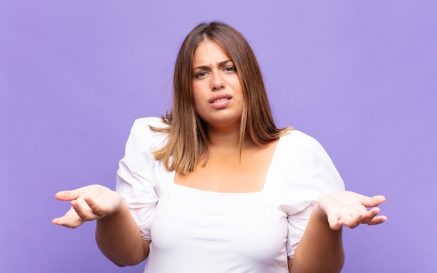 Young blonde woman feeling clueless and confused, not sure which choice or option to pick, wondering