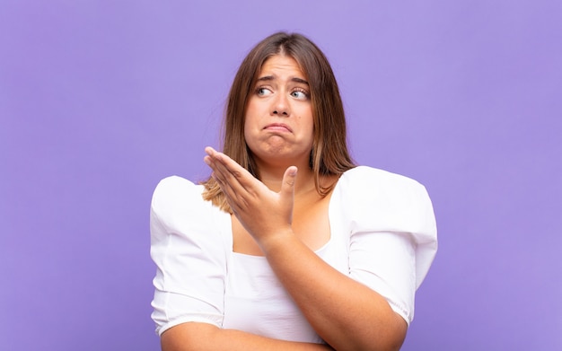 Young blonde woman feeling confused and clueless, wondering about a doubtful explanation or thought