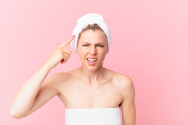 混乱して困惑している若いブロンドの女性は、あなたが狂気でシャワーを浴びた後であることを示しています