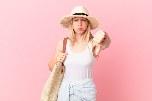 Young blonde woman feeling cross,showing thumbs down