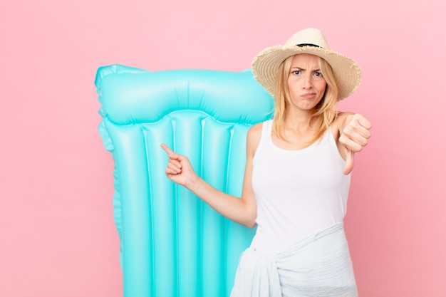 Young blonde woman feeling cross,showing thumbs down