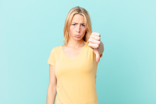 Young blonde woman feeling cross,showing thumbs down