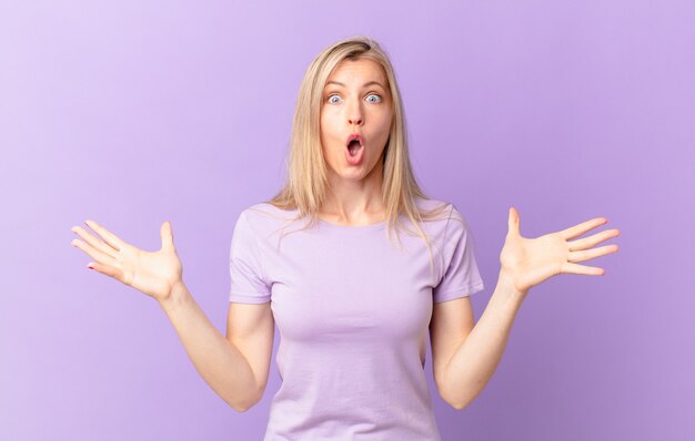 Young blonde woman feeling extremely shocked and surprised