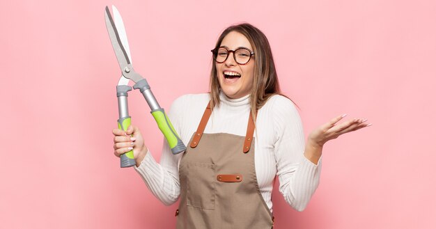 Young blonde woman feeling happy, excited, surprised or shocked, smiling and astonished at something unbelievable