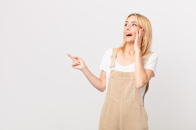 Young blonde woman feeling happy, excited and surprised