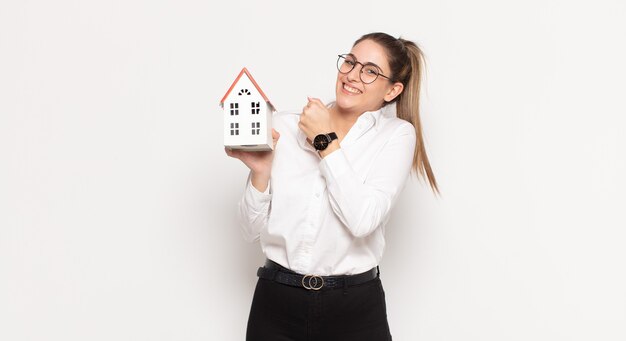 Young blonde woman feeling happy, positive and successful, motivated when facing a challenge or celebrating good results