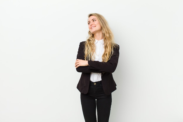 Young blonde woman feeling happy, proud and hopeful