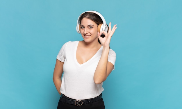 Young blonde woman feeling happy, relaxed and satisfied, showing approval with okay gesture, smiling