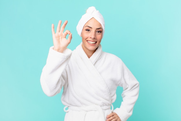 Young blonde woman feeling happy, showing approval with okay gesture. shower concept.