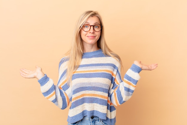 Young blonde woman feeling puzzled and confused and doubting