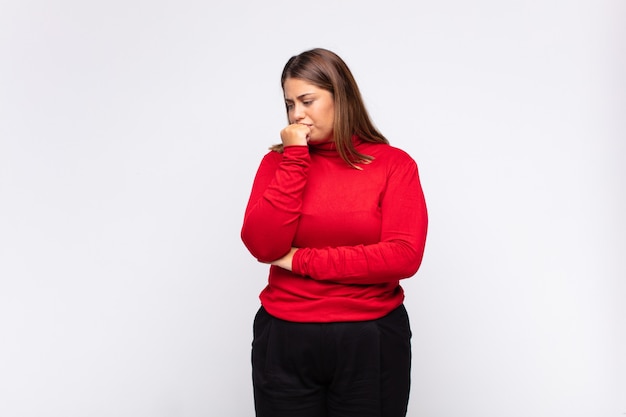 young blonde woman feeling serious, thoughtful and concerned, staring sideways with hand pressed against chin