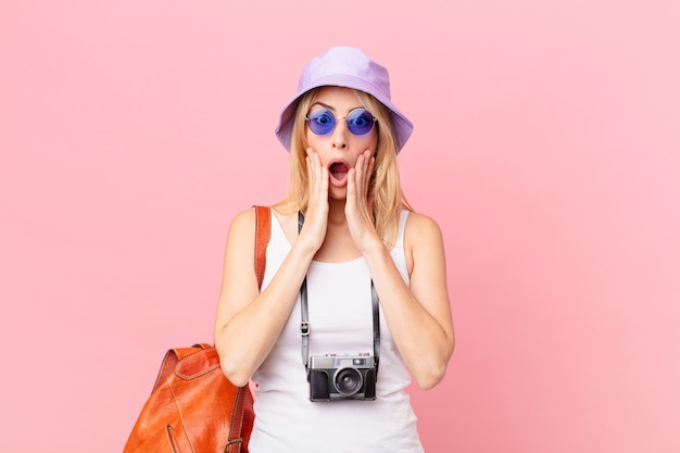 Young blonde woman feeling shocked and scared