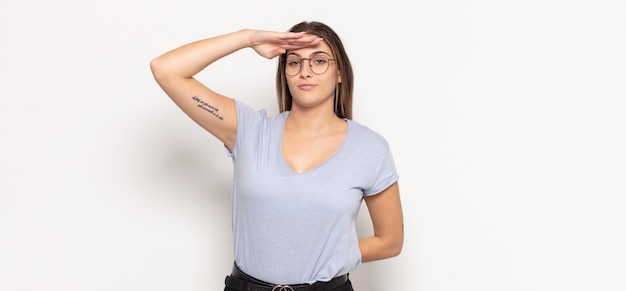 Young blonde woman greeting the camera with a military salute in an act of honor and patriotism, showing respect