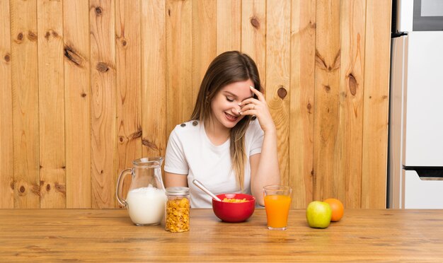 笑って朝食を持つ若いブロンドの女性