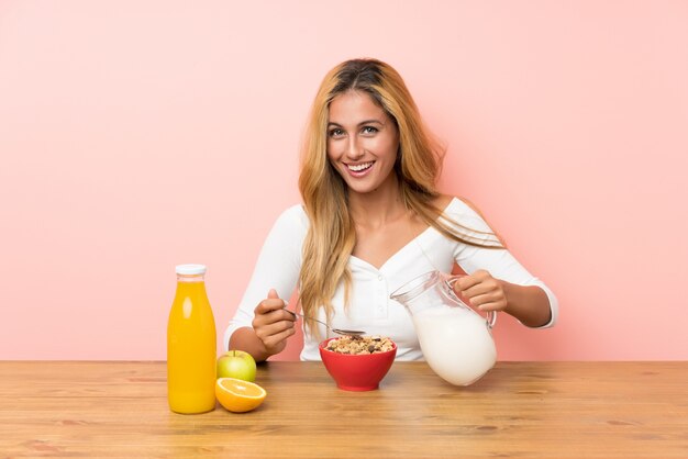 Young blonde woman having breakfast milk