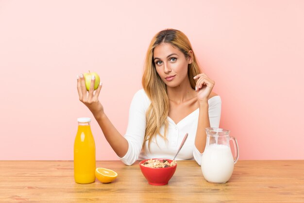 Young blonde woman having breakfast milk