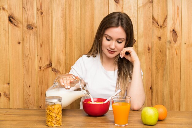 朝食を食べて若いブロンドの女性