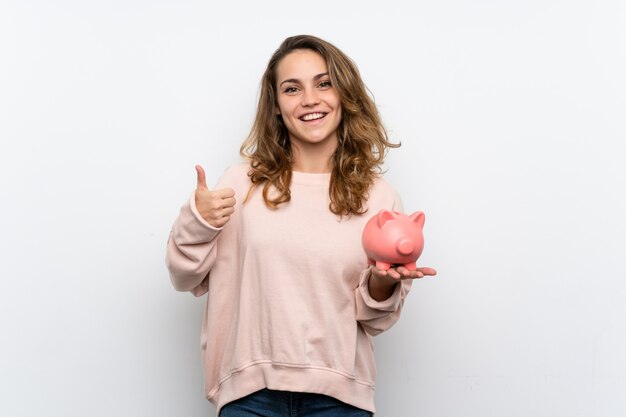 Young blonde woman holding a big piggybank