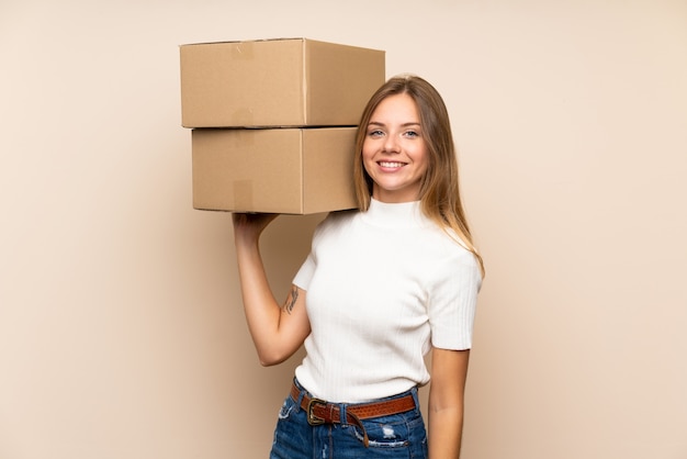 Young blonde woman holding a box to move it to another site