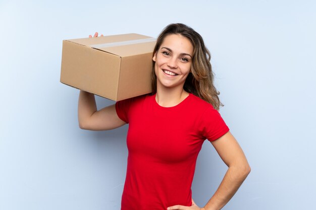 Young blonde woman holding a box to move it to another site