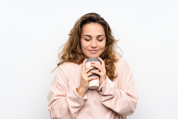 Young blonde woman holding coffee to take away