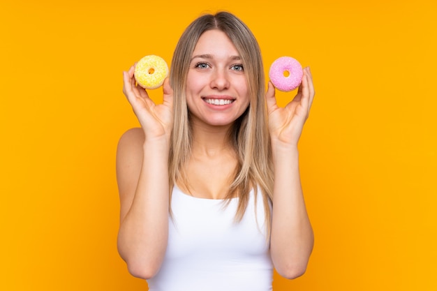 Photo young blonde woman holding donuts