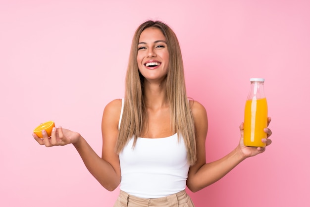 Young blonde woman holding an orange