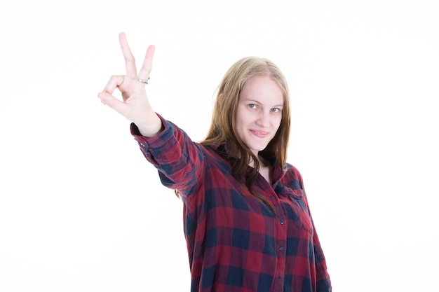 Фото Молодая блондинка на изолированном белом фоне, улыбаясь со счастливым лицом, делает знак победы v пальцами и номер два руки