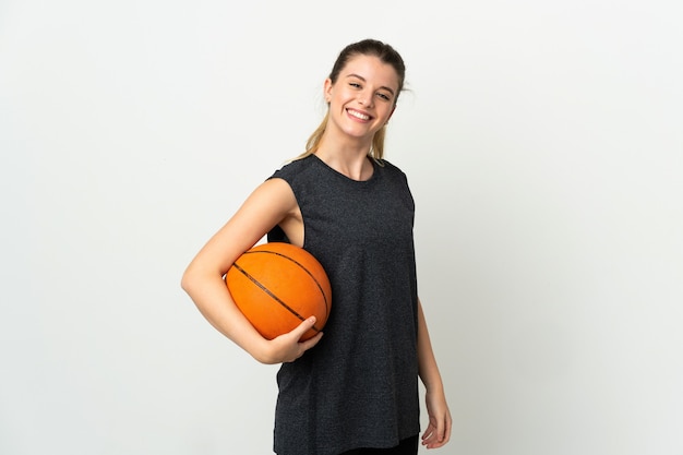 Young blonde woman over isolated space playing basketball