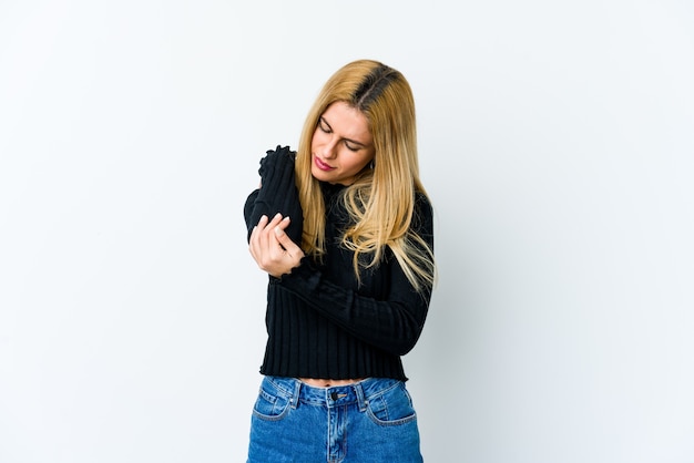 Young blonde woman isolated on white massaging elbow, suffering after a bad movement.