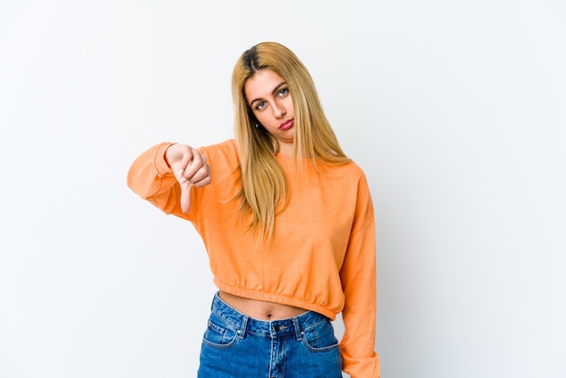 Young blonde woman isolated on white showing a dislike gesture, thumbs down