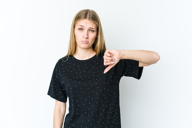 Young blonde woman isolated on white wall showing a dislike gesture, thumbs down. Disagreement concept.