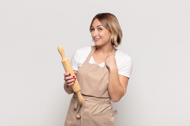 Young blonde woman looking arrogant, successful, positive and proud, pointing to self