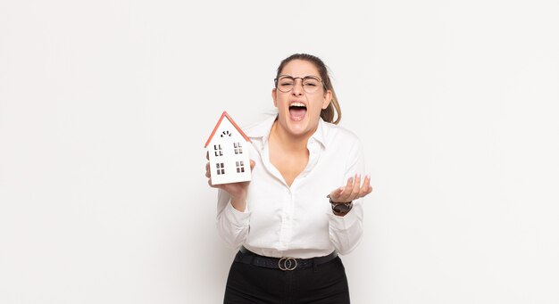 Young blonde woman looking desperate and frustrated, stressed, unhappy and annoyed, shouting and screaming