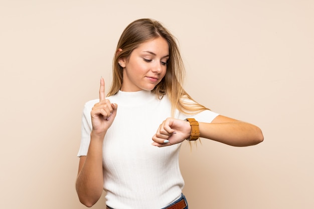 Young blonde woman looking at the hand watch